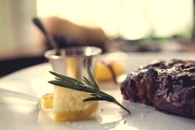 Limon, biber biber ve ahşap masa üzerinde kayısı sos ızgara biftek. Seçici odak.