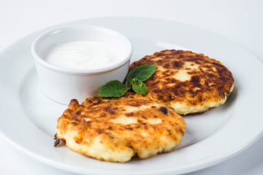 Rustik tatlı, ekşi krema ve izole nane ile bir plaka üzerinde cheesecakes