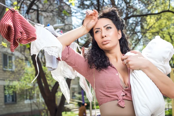 Mother with baby doing laundry outdoors — Stock Photo, Image