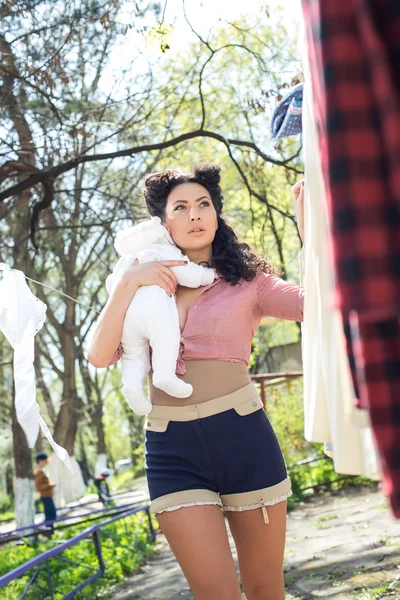 Moeder met baby doen Wasserij buitenshuis — Stockfoto