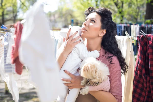 Mãe com bebê fazendo lavanderia ao ar livre — Fotografia de Stock