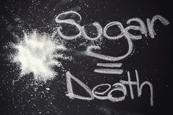Sugar on black chalkboard from above. — Stock Photo, Image