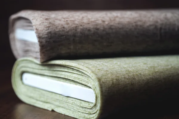 Rolls of fabric on wooden background