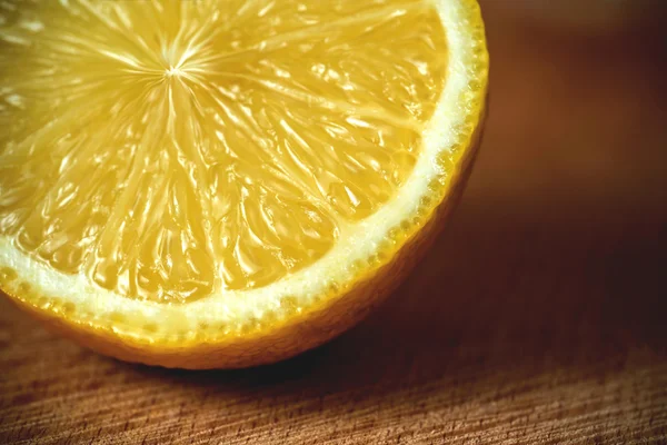 Limón en rodajas en una tabla de cortar. Fondo de madera — Foto de Stock