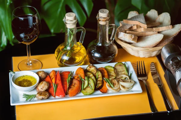 Grilled vegetables on yellow background with a glass of wine,oil,vinegar and bread — Stock Photo, Image