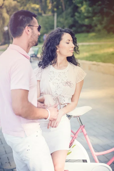 Pareja con bicicleta vintage rosa en el parque de verano —  Fotos de Stock