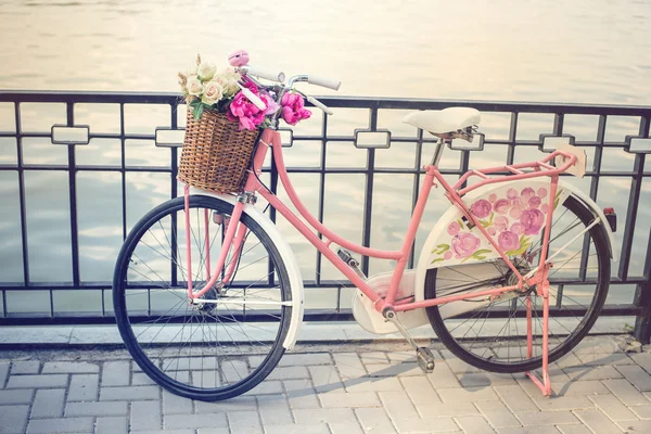 Vintage vélo rose avec panier de fleurs — Photo