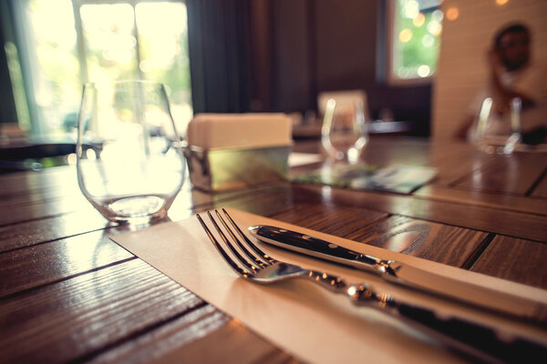 Knife and fork set on a wooden vintage table. Selective Focus