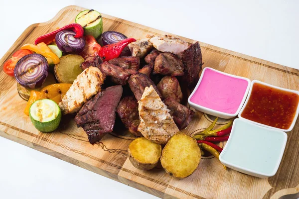 Different kind of grilled meat with sauces on wooden plate. isolated — Stock Photo, Image