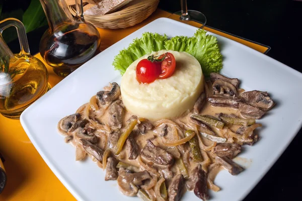 Grilled veal dish served with potato puree, mushrooms sauce and leaf salad — Stock Photo, Image