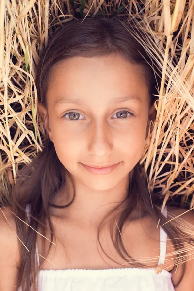 Niña feliz jugando en el campo de trigo al atardecer —  Fotos de Stock