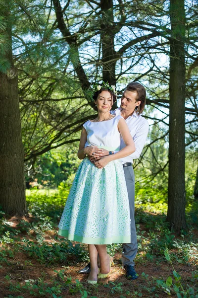 Casal de casamento, bela noiva jovem e noivo de pé em um parque ao ar livre de mãos dadas — Fotografia de Stock