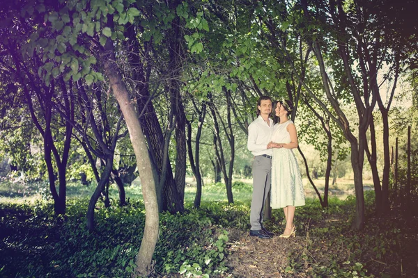 Pareja de boda, hermosa novia joven y el novio de pie en un parque al aire libre tomados de la mano — Foto de Stock