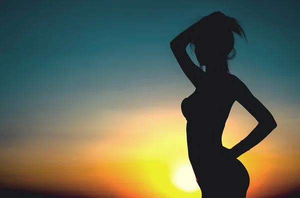 Atardecer, mujer sexy silueta en el techo — Foto de Stock