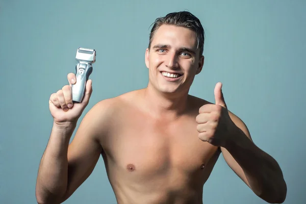 Hombre sosteniendo una máquina de afeitar eléctrica — Foto de Stock