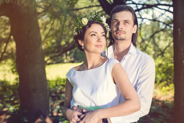 Casal de casamento, bela noiva jovem e noivo de pé em um parque ao ar livre de mãos dadas — Fotografia de Stock