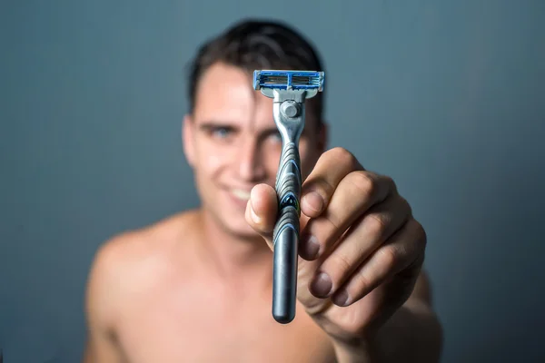 Mano de hombre sosteniendo una máquina de afeitar — Foto de Stock