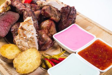 Değişik soslar ahşap plaka üzerinde ızgara et bir. izole