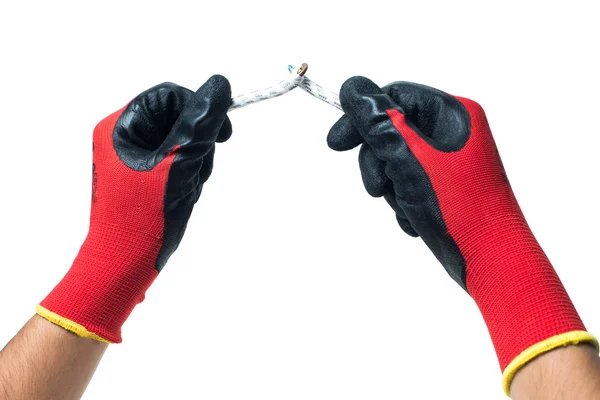 Las manos del constructor en guantes de goma roja fijan el cable. aislado — Foto de Stock