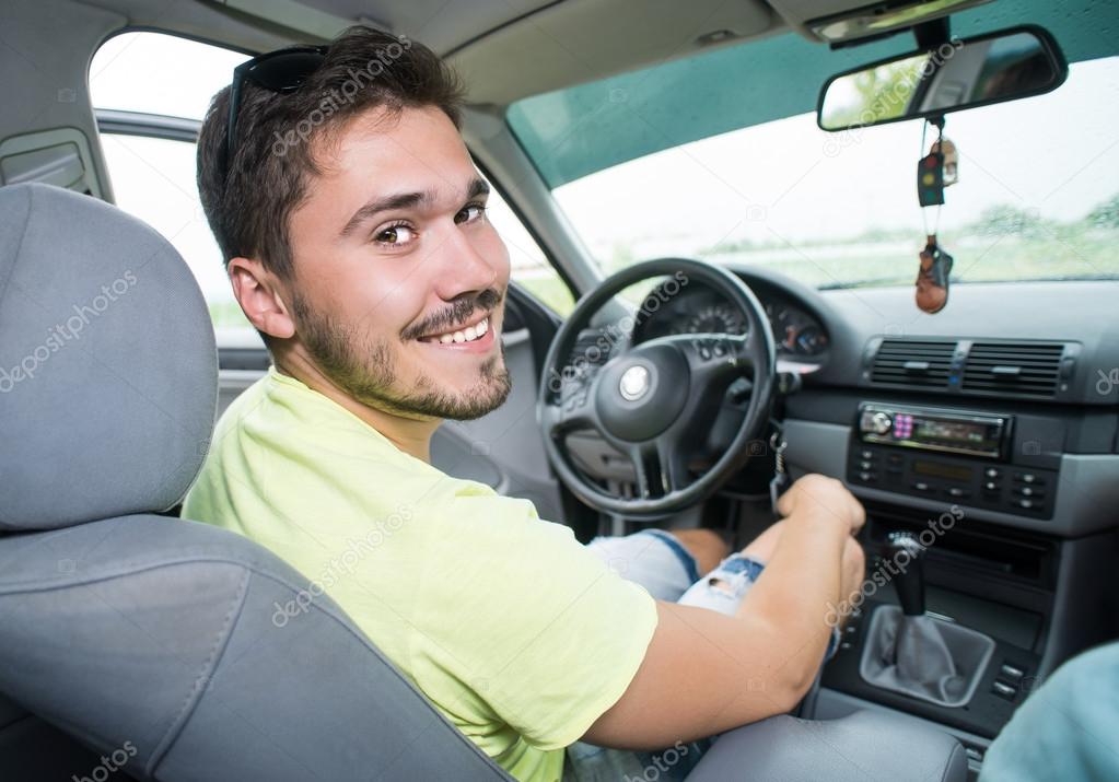 smiling teenager driving a car