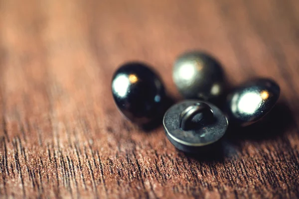 Vintage metal buttons on wood floor background
