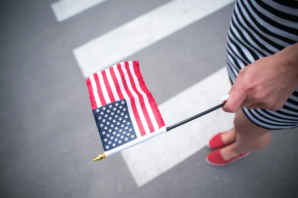 Mujer mano sosteniendo bandera americana — Foto de Stock