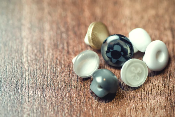 Fermer, boutons en plastique sur fond de plancher en bois. Concentration sélective — Photo