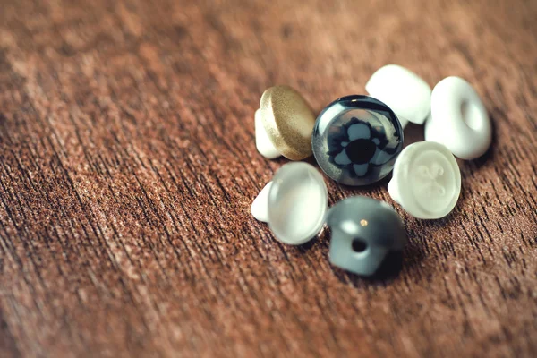 Close up, plastic buttons on wood floor background. Selective focus — Stock Photo, Image