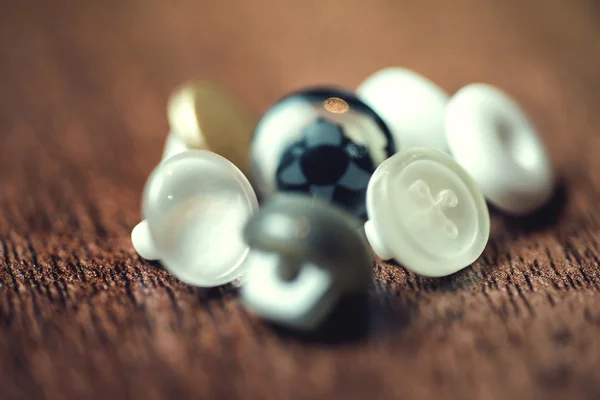 Fermer, boutons en plastique sur fond de plancher en bois. Concentration sélective — Photo