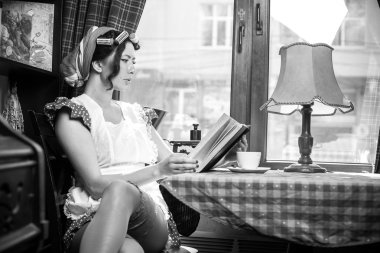 Kahve içme ve kitap oturma kentsel kafede kapalı okuma genç kadın