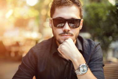 Yakışıklı delikanlı günbatımı üzerinde güneş gözlüğü