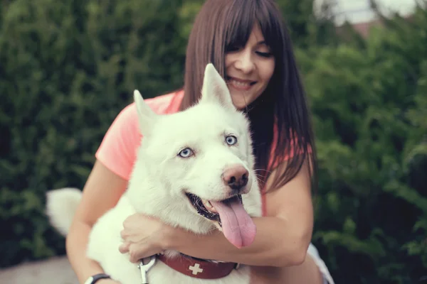 Menina bonita no parque brincando com seu cachorro Husky — Fotografia de Stock