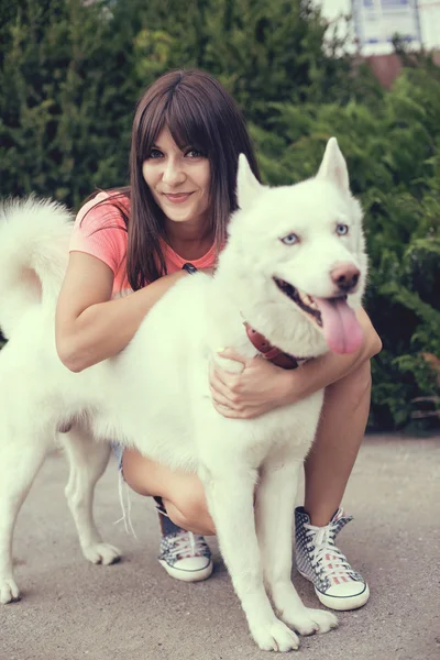 Schönes Mädchen im Park spielt mit ihrem Husky-Hund — Stockfoto