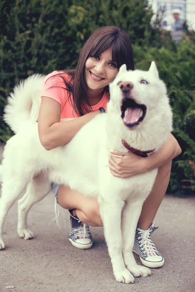 Schönes Mädchen im Park spielt mit ihrem Husky-Hund — Stockfoto