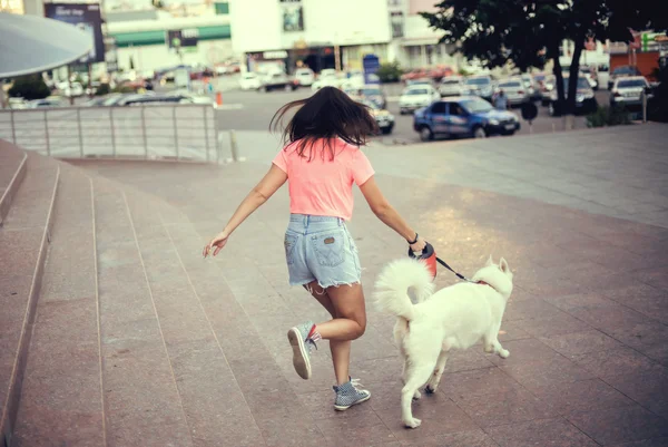 Das Mädchen geht mit ihrem Husky-Hund in der Stadt spazieren — Stockfoto