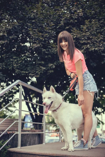 Krásná dívka v parku hrát s její Husky pes — Stock fotografie