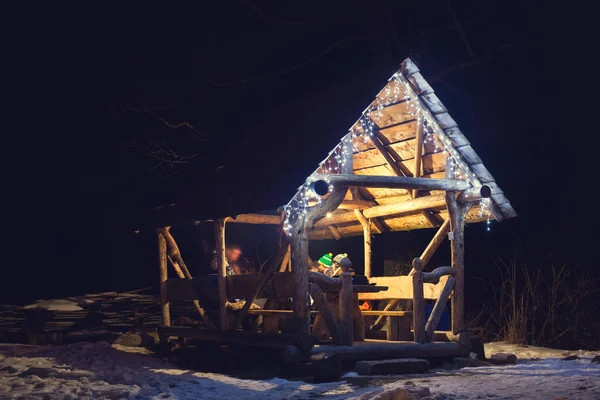 Pessoas sentadas ao lado do fogo à noite no mirante de madeira — Fotografia de Stock