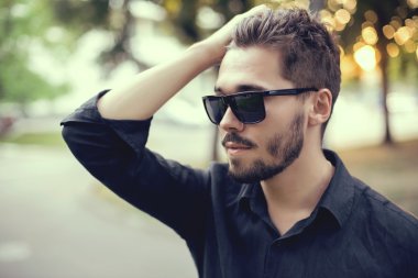 Yakışıklı delikanlı günbatımı üzerinde güneş gözlüğü