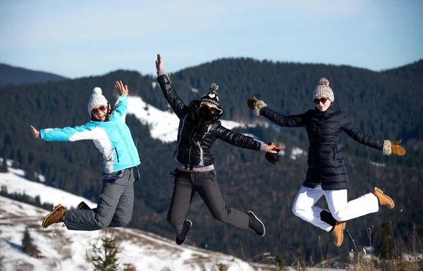 Tre flickor hoppa tillsammans under vintern. Mountain bakgrund — Stockfoto