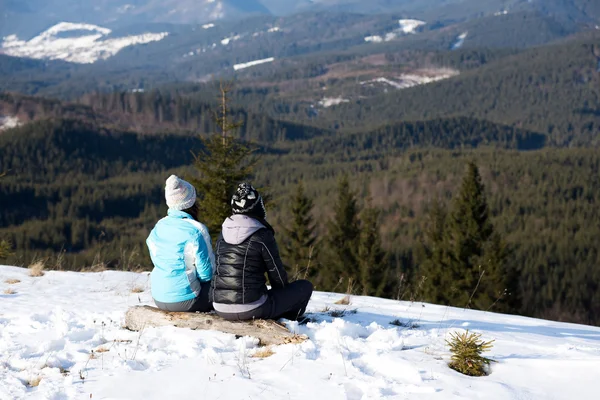 Meisjes genieten van uitzicht op de bergen samen in de winter. — Stockfoto