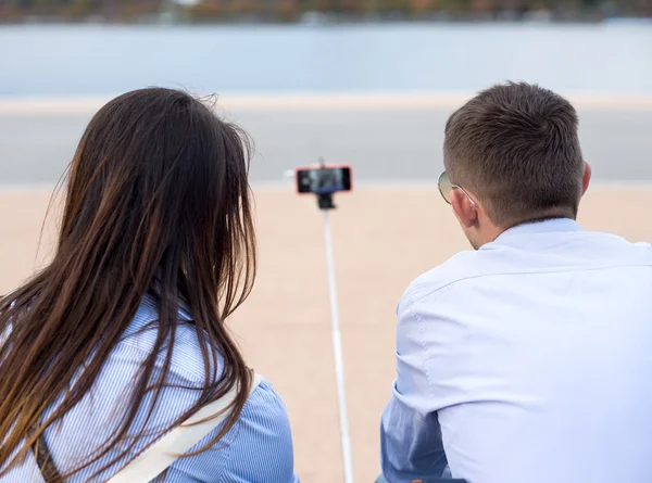 Jovem casal tirando uma selfie com smartphone na vara . — Fotografia de Stock