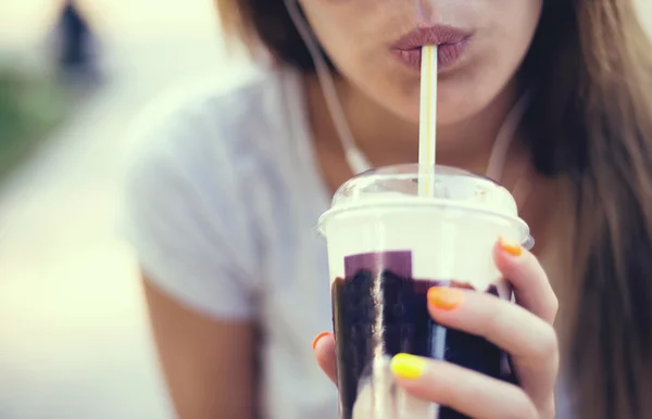 Pretty smiling girl with milk shake sitting on bench at street cafe — Stock Photo, Image