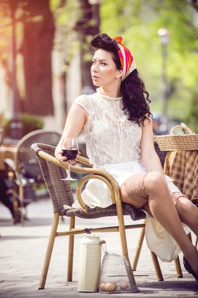 Mooi meisje met glas rode wijn alleen in een straat café — Stockfoto