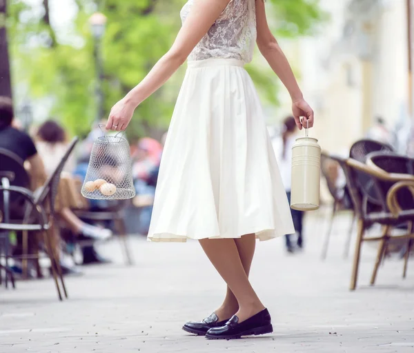 Donna che gira per strada con una lattina e un cesto con uova — Foto Stock