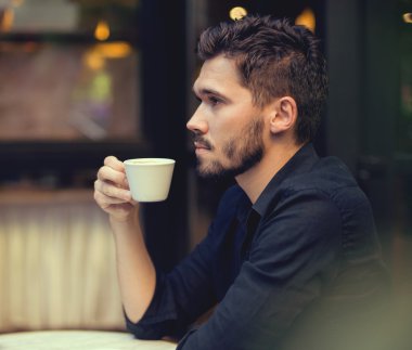 Tatlı adam cep telefonu açık havada seyir kahve ile