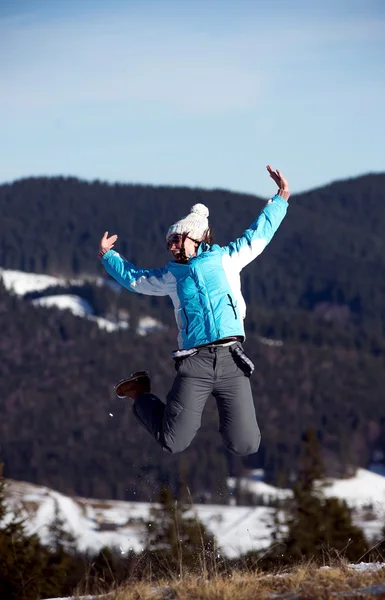 Dziewczyna skoki w okresie zimowym. Tle góry — Zdjęcie stockowe
