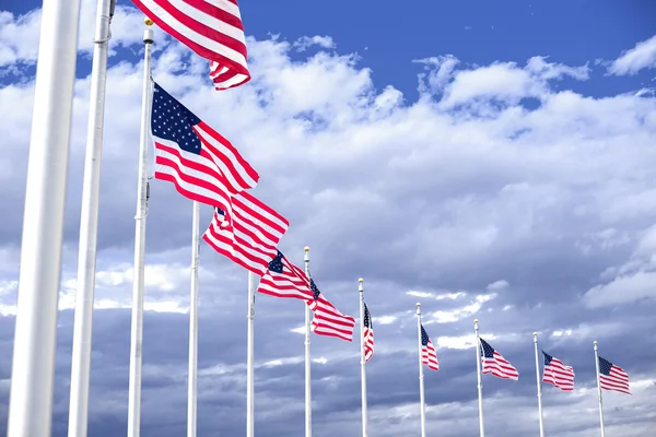 Banderas americanas serpenteando en el cielo azul — Foto de Stock