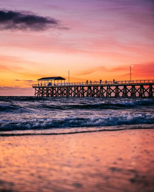 Günbatımı bulutları okyanusun üzerinde Grange, Güney Avustralya 'da bir martı sürüsüyle..