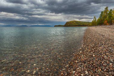 Baykal 'ın berrak sularıyla kaplı manzara, bulutlu öğleden sonra. 