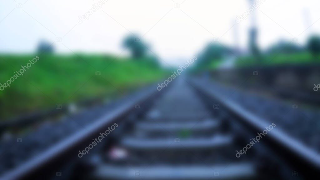 Blurred train tracks background. blurred train tracks with green trees